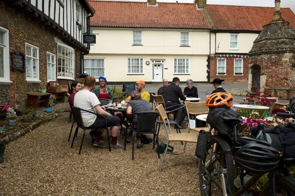 Cyclists at a coffee shop in a village centre.