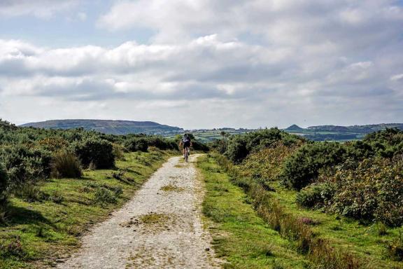 A rider on a trail with panoramic views of the moor around.